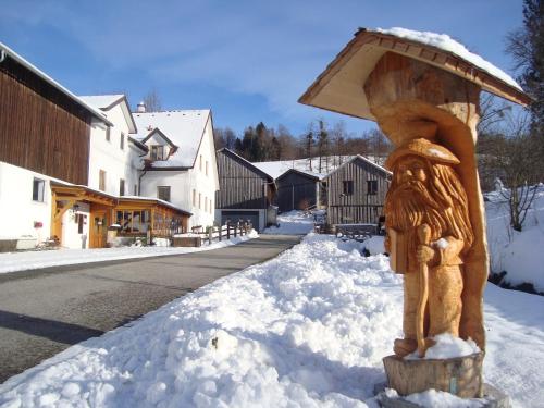 a statue of a person with a umbrella in the snow at Einkehrhof Poggau in Reinsberg