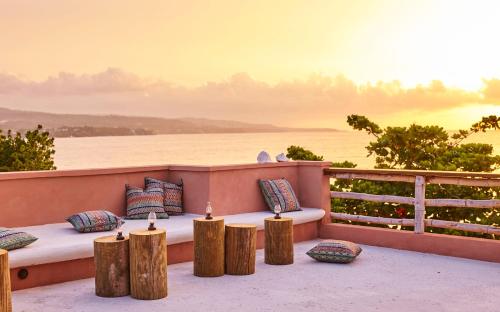 a deck with a bed and pillows on a balcony at GoldenEye in Oracabessa