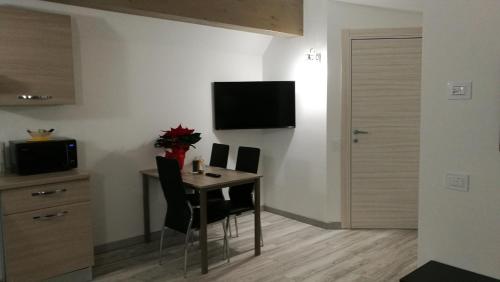 ヴェッツァ・ドーリオにあるVilla Elisaのダイニングルームテーブル(椅子付)、壁掛けテレビが備わります。