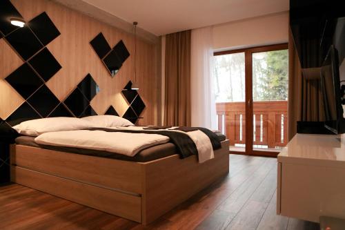 Un dormitorio con una cama grande con cabecero de madera. en Apartmán 17 Romantika Chopok Juh Tále, en Tale