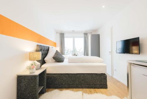 1 dormitorio con 1 cama grande y TV en Unique Inn, en Schöngeising