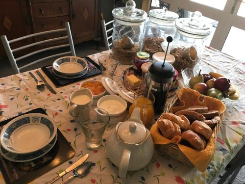 Newlands Bed and Breakfast في West Melton: طاولة مع قطعة قماش عليها طعام