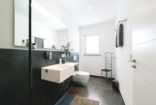 a bathroom with a white sink and a toilet at Unique Inn in Schöngeising