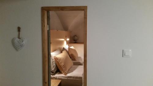 a mirror in a bedroom with a bed with pillows at Maison à Tour Briançon in Briançon