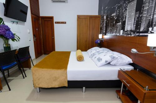 um quarto com uma cama e uma cabeceira em madeira em Hotel Sauces del Estadio em Medellín