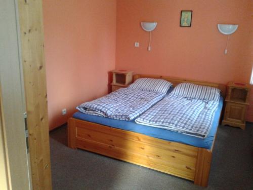 - une chambre avec un lit doté d'un cadre en bois dans l'établissement APARTMÁN GALERIE, à Harrachov