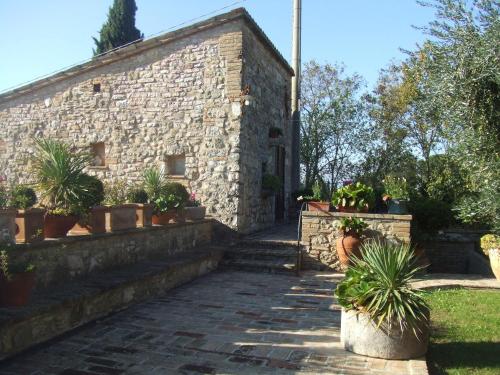 an old stone building with potted plants in front of it at Country House Tre Esse in Assisi