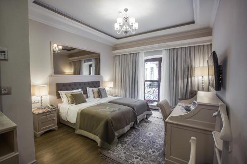 Un dormitorio con una cama grande y una lámpara de araña. en Boutique 19 Hotel, en Baku