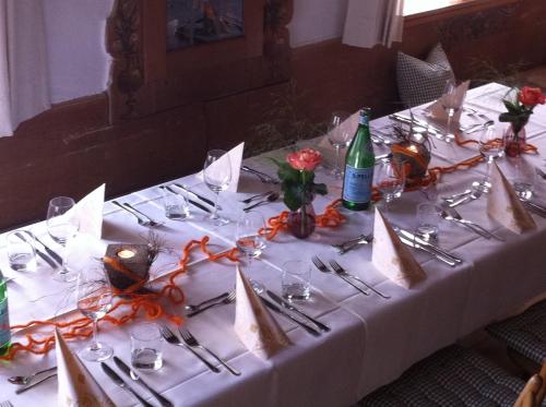 a table with a white table cloth with wine bottles and glasses at Zum Kirchenbauer in Oberammergau