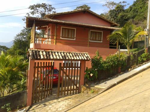 una casa roja con una puerta delante de ella en Chale Por do Sol, en Ilhabela
