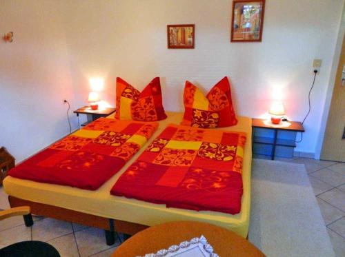マルヒョーにあるFerienwohnung Malchow SEE 8241のベッドルーム1室(ベッド2台、赤と黄色の枕付)