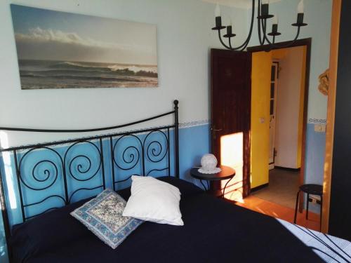een slaapkamer met een bed met een blauw hoofdeinde bij Fontana's House Relax in Valbravenna