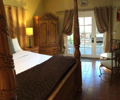 um quarto com uma cama grande e uma porta para um pátio em Glen Ellen Inn Secret Cottages em Glen Ellen