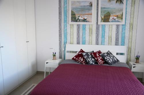 a bedroom with a bed with red and black pillows at Casa Marinero with Private Pool in Puerto del Rosario