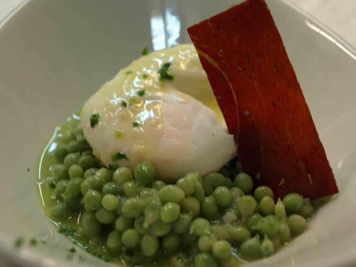 a plate of food with peas and a poached egg at Hotel Txartel in Lasarte