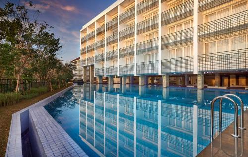 a swimming pool in front of a building at The Sintesa Jimbaran Bali in Jimbaran