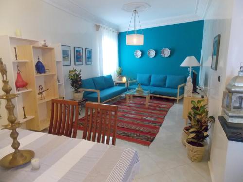 a living room with blue couches and a table at Dar lhadja in El Jadida