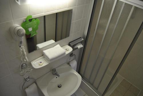 a bathroom with a toilet and a sink and a mirror at Hotel Heidenschanze in Dresden