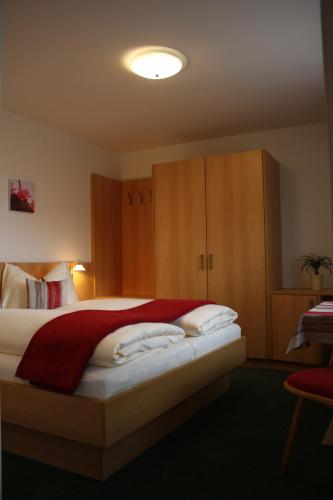 a bedroom with a bed and wooden cabinets at Zimmervermietung Babsy in Zell am See