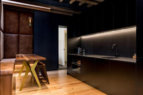 cocina con fregadero y mesa de madera en 105 Mac Unique Apartments, en Hobart