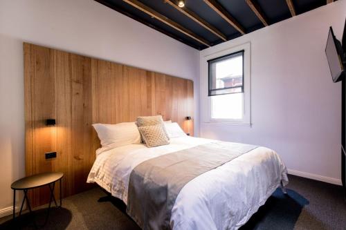 Un dormitorio con una cama grande y una ventana. en 105 Mac Unique Apartments, en Hobart