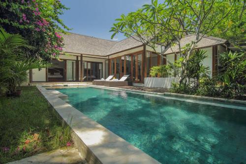 a swimming pool in front of a house at Ningaloo Villa in Gili Trawangan