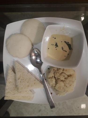 um prato de comida com uma tigela de molho e bolachas em Hotel Alfa International em Mumbai