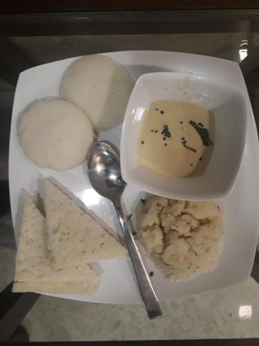 a plate of food with a bowl of dip and crackers at Hotel Alfa International in Mumbai