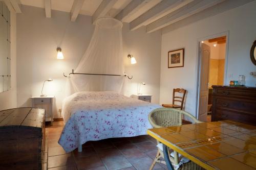 a bedroom with a bed with a dresser and a table at Ecuries Sainte Croix in Carcassonne