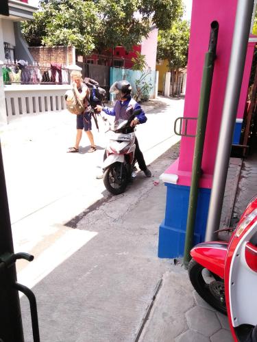 a person on a scooter parked on a street at Homestay Lidiya in Banyuwangi