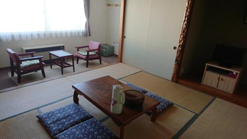 ein Wohnzimmer mit Couchtisch und Stühlen in der Unterkunft Silver Shiga in Yamanouchi