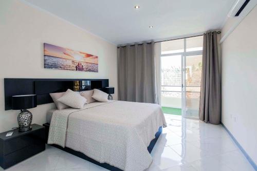 1 dormitorio con cama y ventana grande en Luxury Appartements Playa Paraiso, en Playa Paraiso