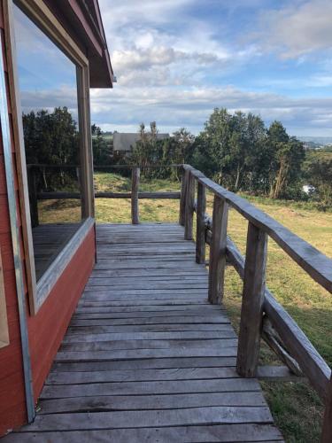 a wooden boardwalk leading to a building with a window at Terrazas altos de Gamboa in Castro