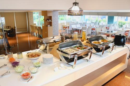 a buffet with food on a table in a restaurant at Maverick Ratchada Hotel in Bangkok