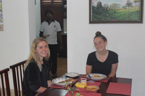 two women sitting at a table eating food at Natures Bliss Holidays in Ja-Ela