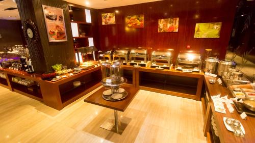 a restaurant with a bar with a counter with food at Metropolo, Guangzhou, Wanda Plaza-Baiyun Mountain in Guangzhou