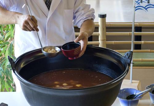 Un chef preparando comida en una olla sobre una mesa. en Kashikojima Hojoen, en Shima