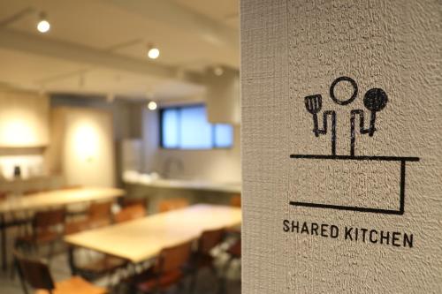 a sign on a wall with a shared kitchen at LINNAS Kanazawa in Kanazawa