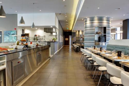 a large kitchen with tables and chairs in a restaurant at Premier Inn Dubai Ibn Battuta Mall in Dubai
