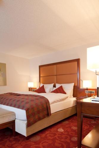 a hotel room with a large bed and a desk at Zu den Drei Linden - Hotel & Restaurant in Wermelskirchen