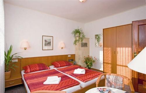 a bedroom with a large bed with red pillows at Onkel Tom`s Hütte in Göttingen