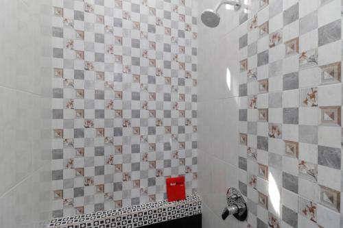 baño con pared de azulejos con caja roja en RedDoorz Plus near RS Royal Prima Medan, en Medan