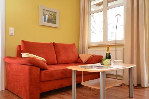 オストゼーバート・ゼリンにあるVilla Seerose - Appartement 13のリビングルーム(赤いソファ、テーブル付)