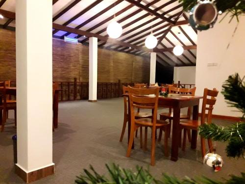 a dining room with a table and wooden chairs at Nico Lagoon Hotel in Negombo