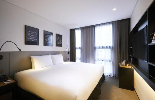 a hotel room with a large bed and a television at GLAD Gangnam COEX Center in Seoul