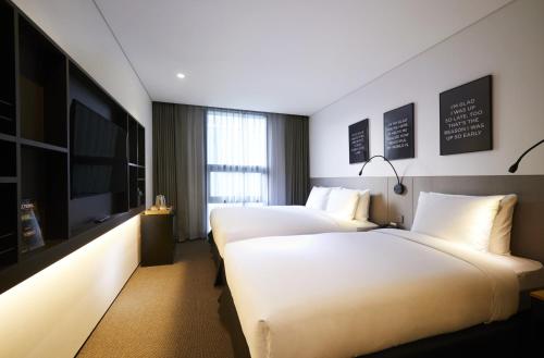 A bed or beds in a room at GLAD Gangnam COEX Center