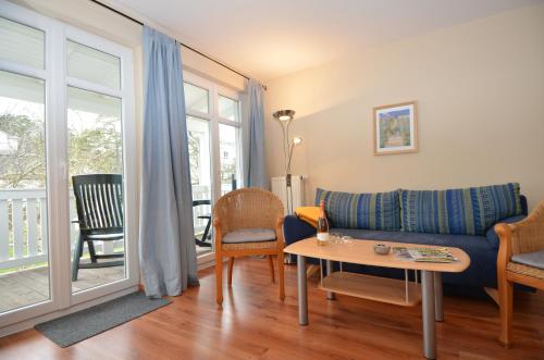a living room with a couch and a table at Villa Seerose - Appartement 18 in Ostseebad Sellin