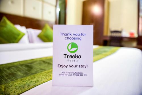 una señal sentada encima de una cama en Hotel Habitat Comforts, en Bangalore