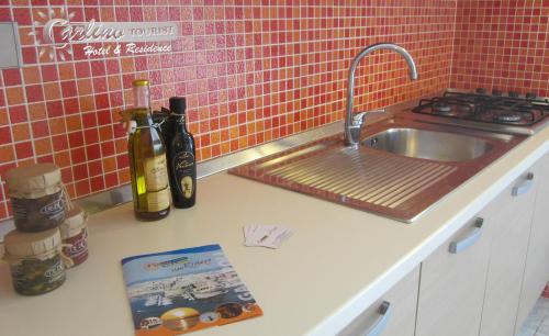 a kitchen counter with a sink and a book at Appartamenti Baia Verde Gallipoli di Carlino Tourist in Gallipoli