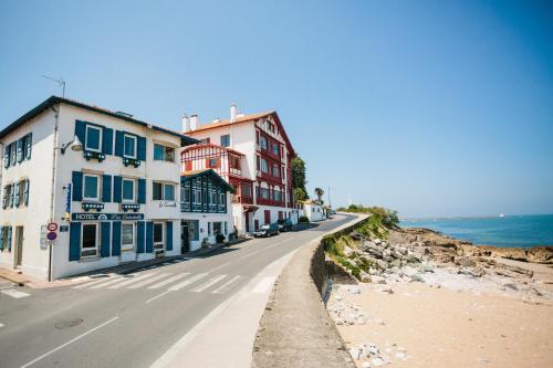 a street with buildings on the side of the ocean at Hôtel La Caravelle in Ciboure